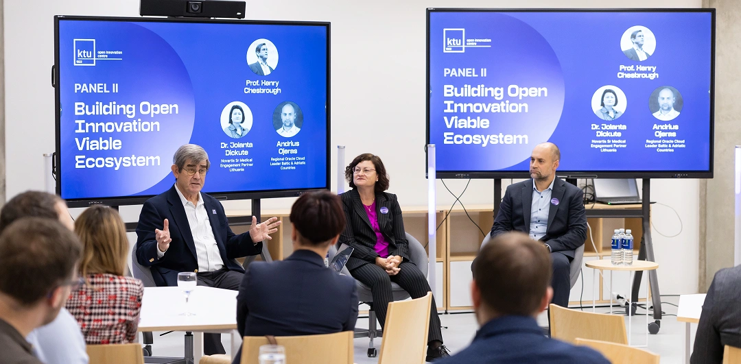 Internal resources are no longer enough Three keynote speakers addresses an audience seated at tables in a bright, modern conference room, with KTU Open Innovation Centre branding displayed on screens.